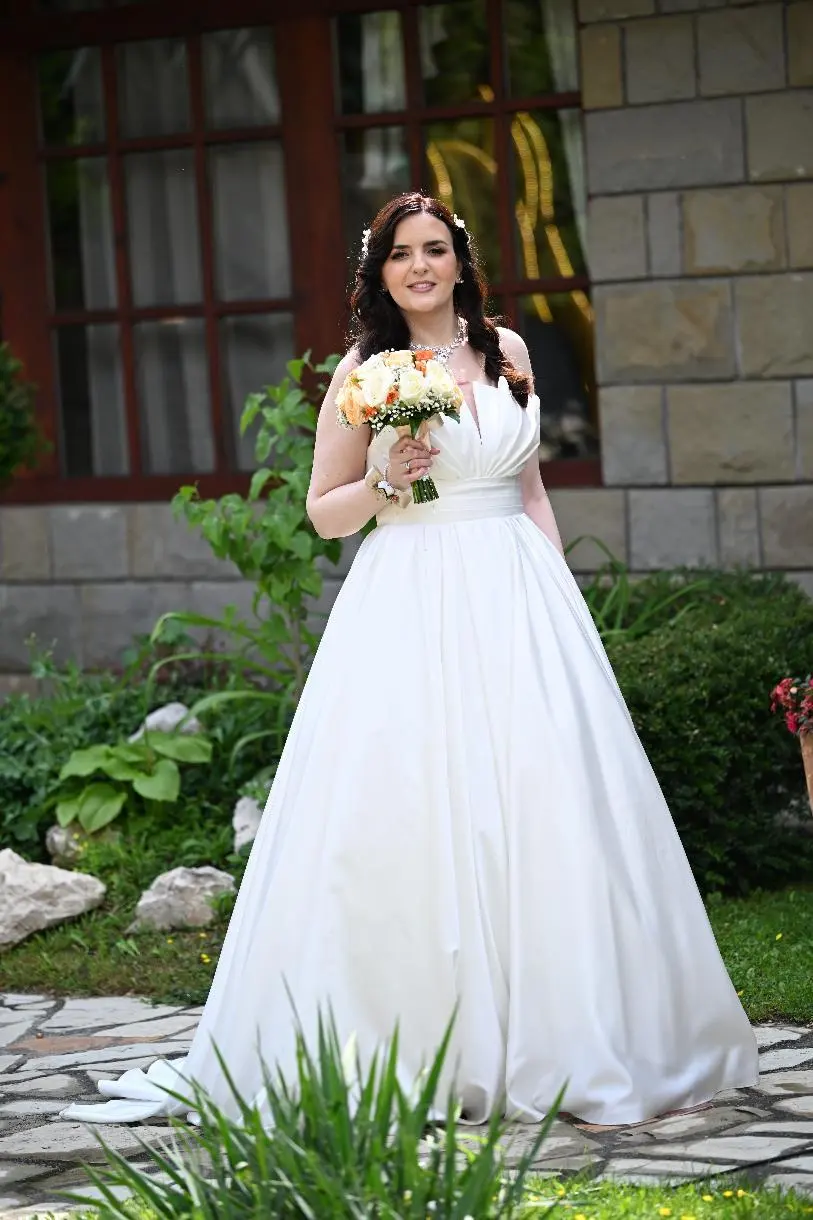 Jelena u satenskoj venčanici kroja princeza sa buketom
