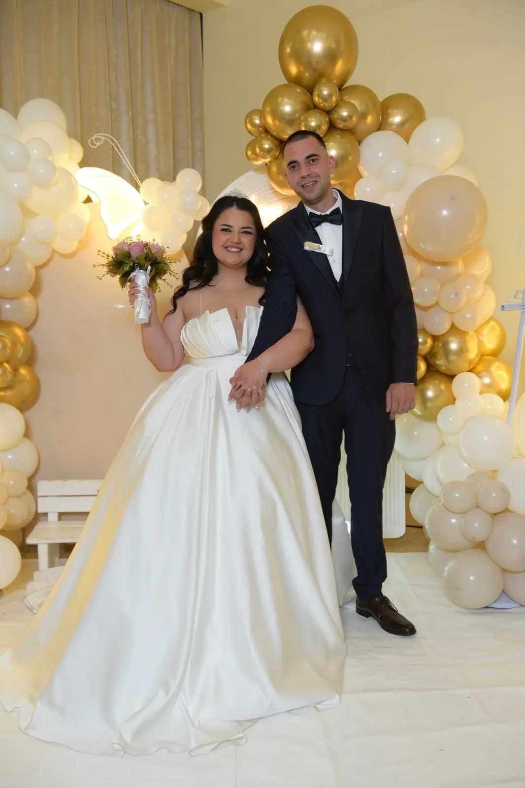 Mlada i mladoženja na proslavi među zlatnim balonima