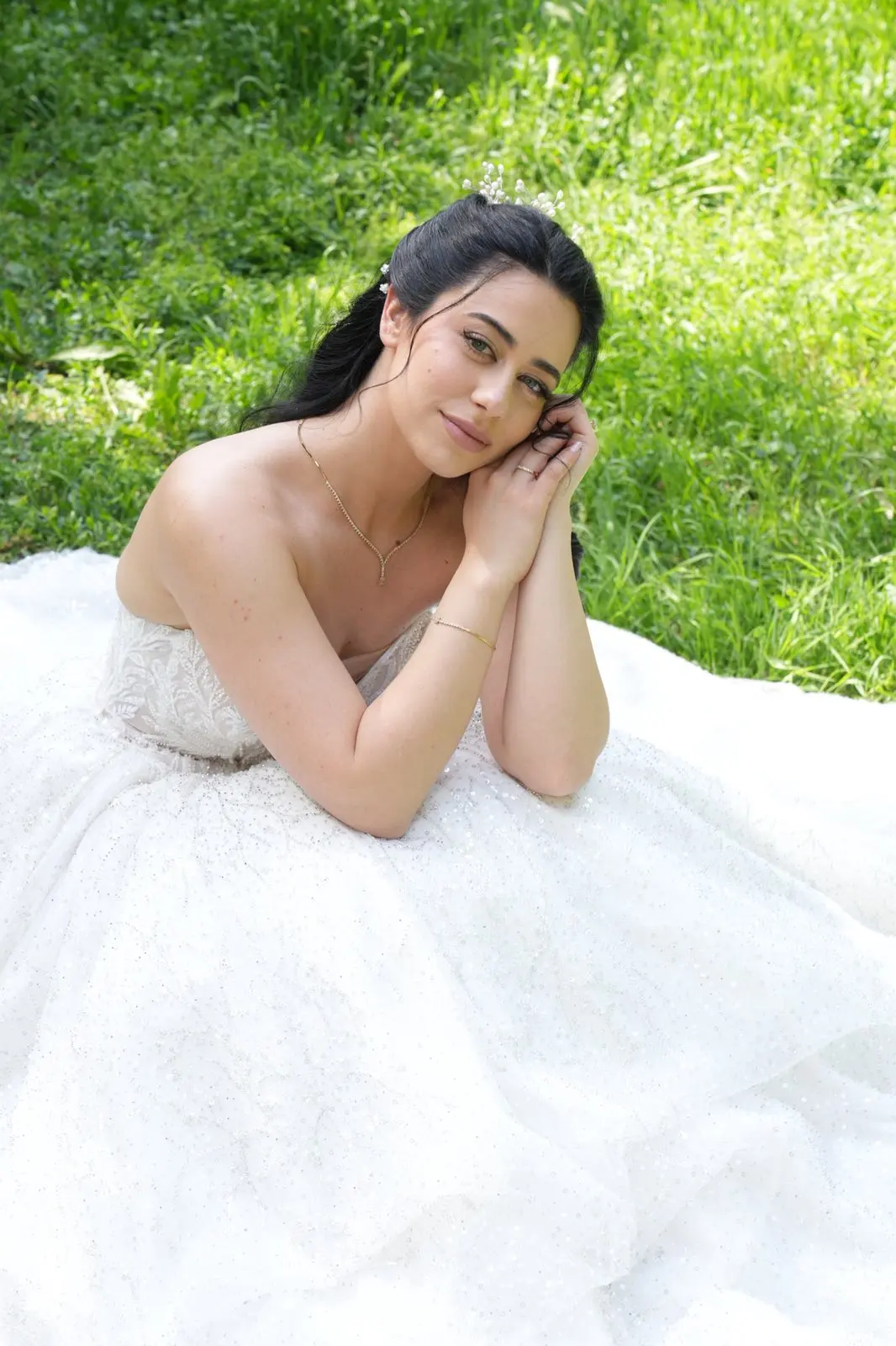 Sanja sedi na travi u venčanici kroja princeza sa šljokicama