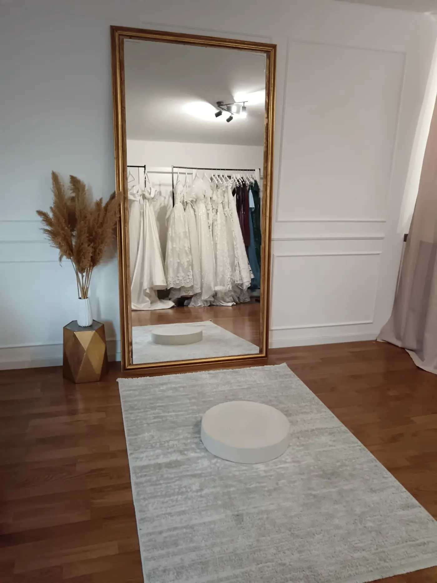 Zlatno ogledalo i šipka sa venčanicama u salonu
